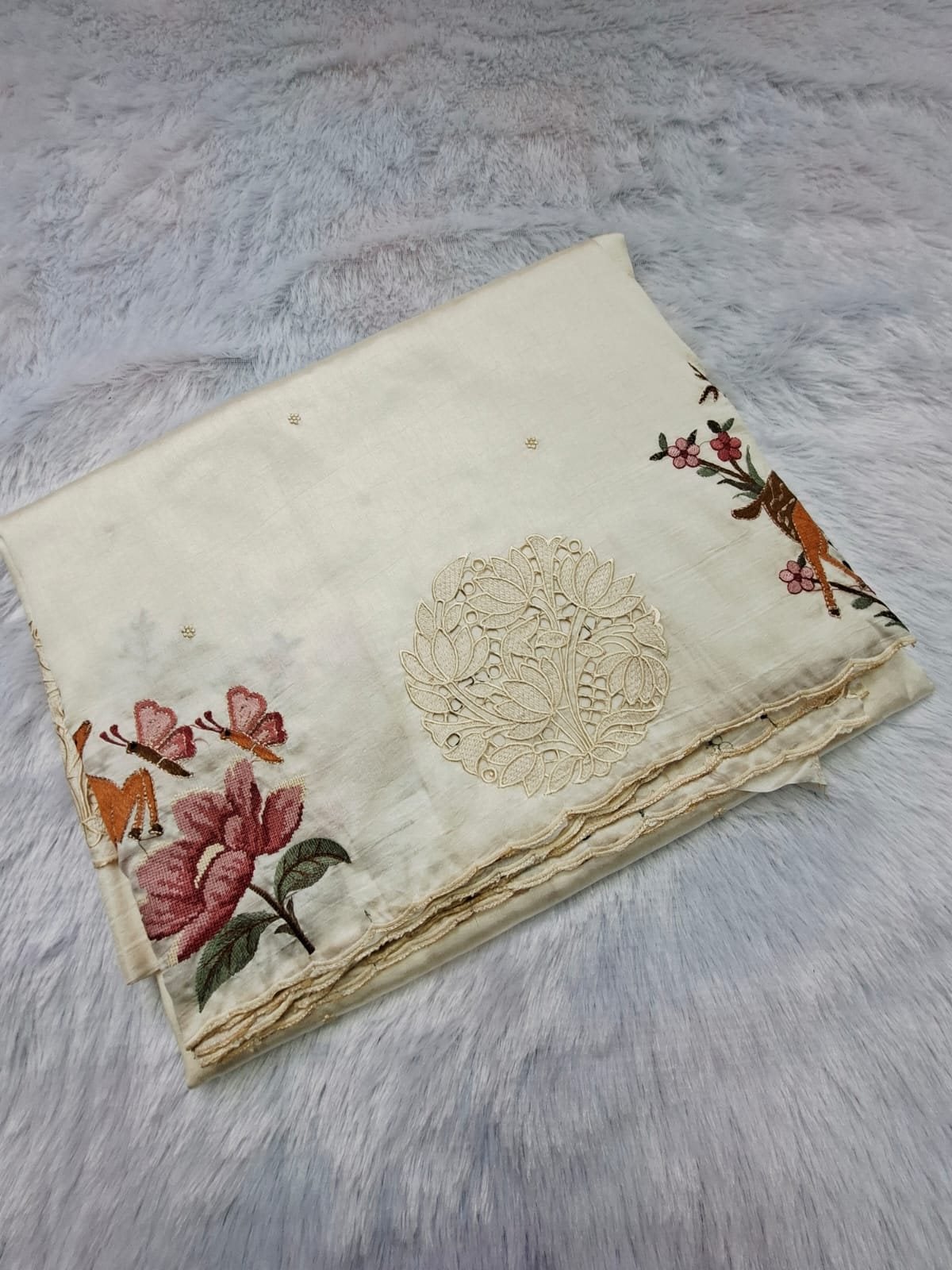 Ivory pure raw silk saree with cut-work medallion and embroidered deer, folded