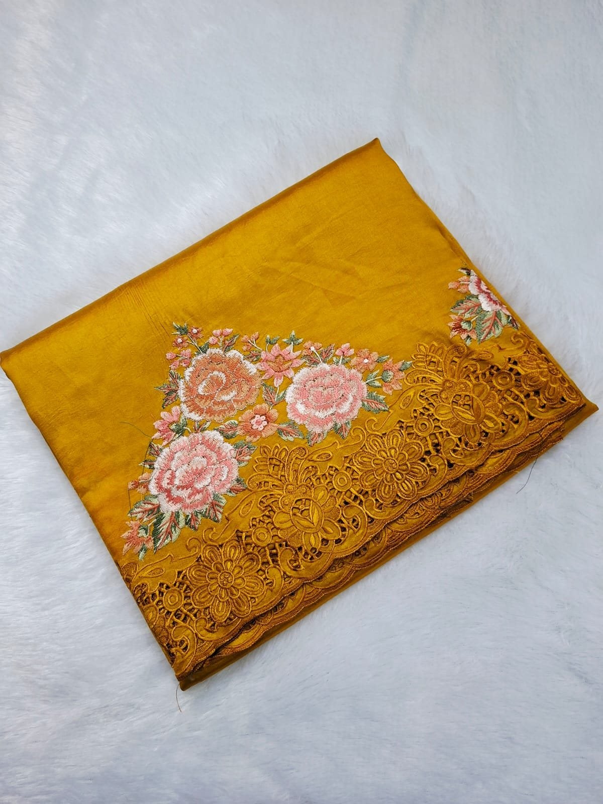 Mustard pure raw silk saree with rose embroidery and cut-work border, folded