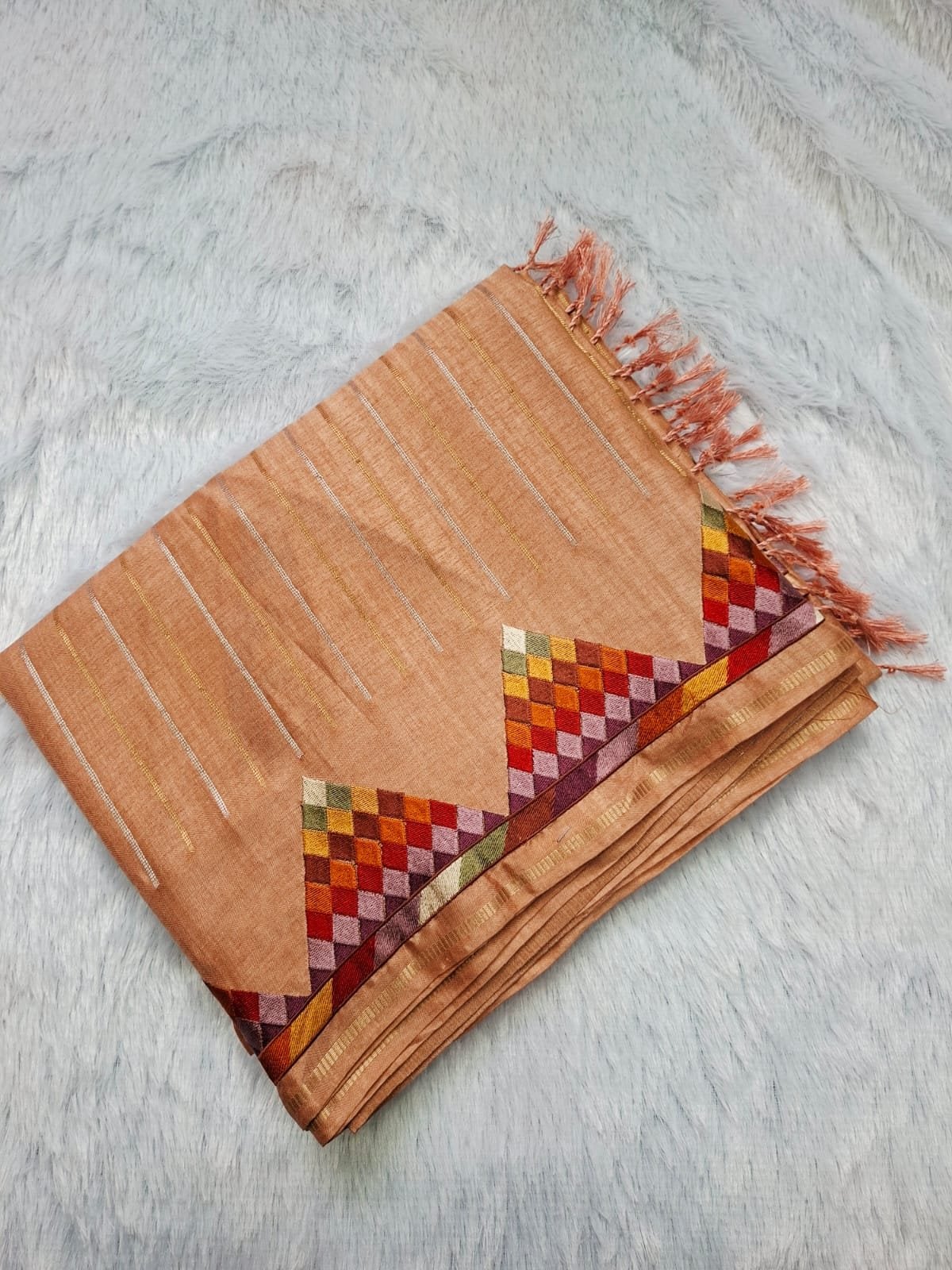 Beige viscose tussar saree with geometric work, folded