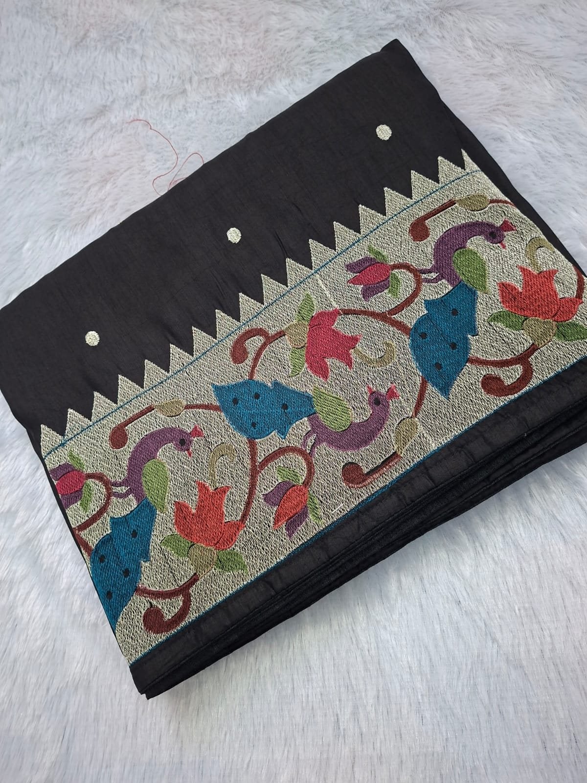 Black raw silk saree with German silver Paithani border, folded