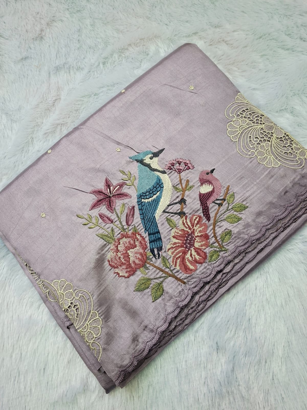 Lilac grey raw silk saree with blue jay embroidery, folded