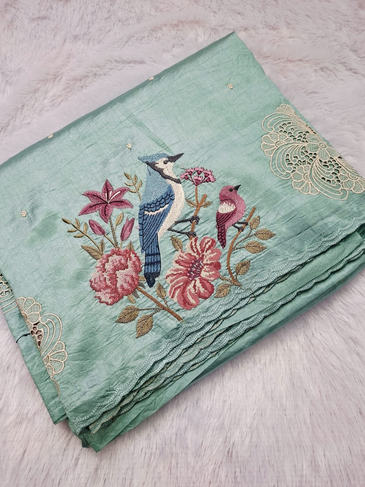 Mint raw silk saree with blue jay embroidery, folded