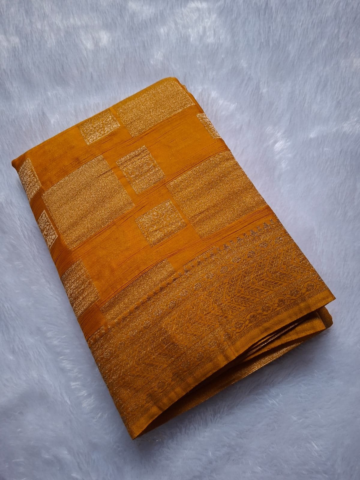 Mustard premium georgette saree with geometric zari blocks, folded