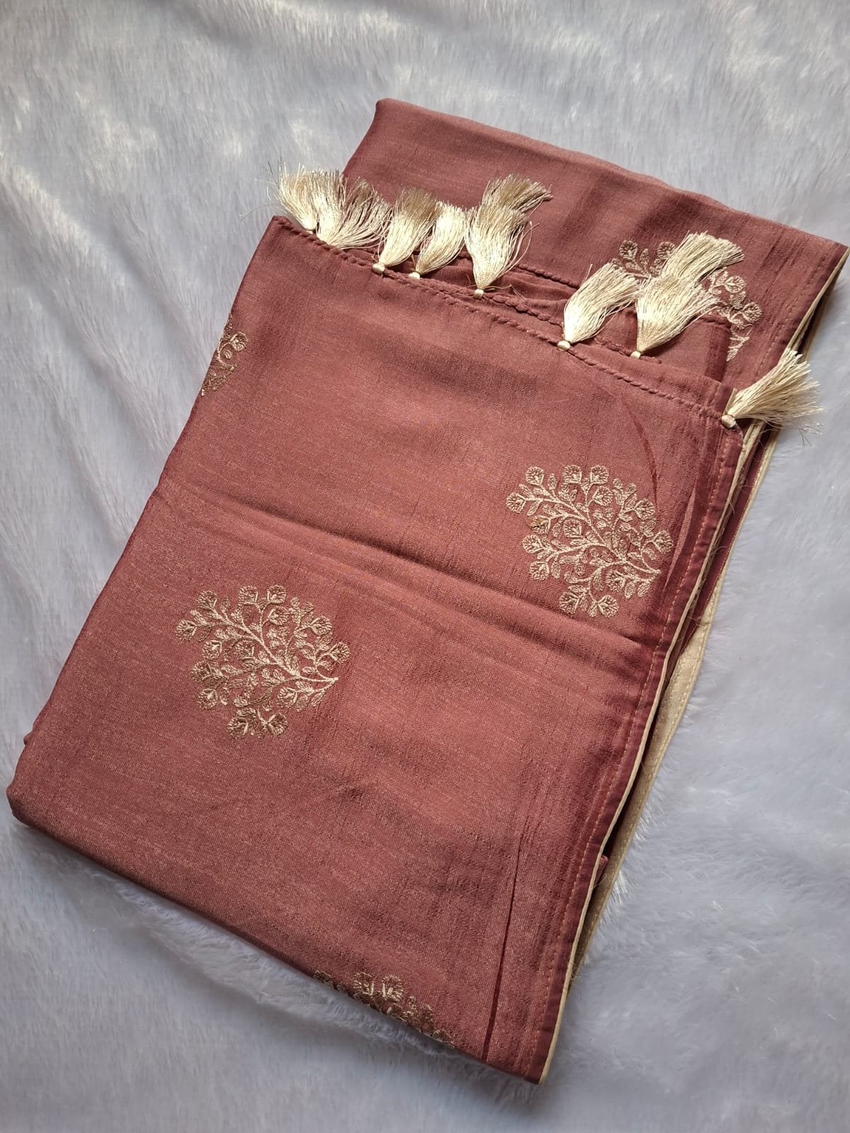 Terracotta thread embroidery saree with tassels, folded