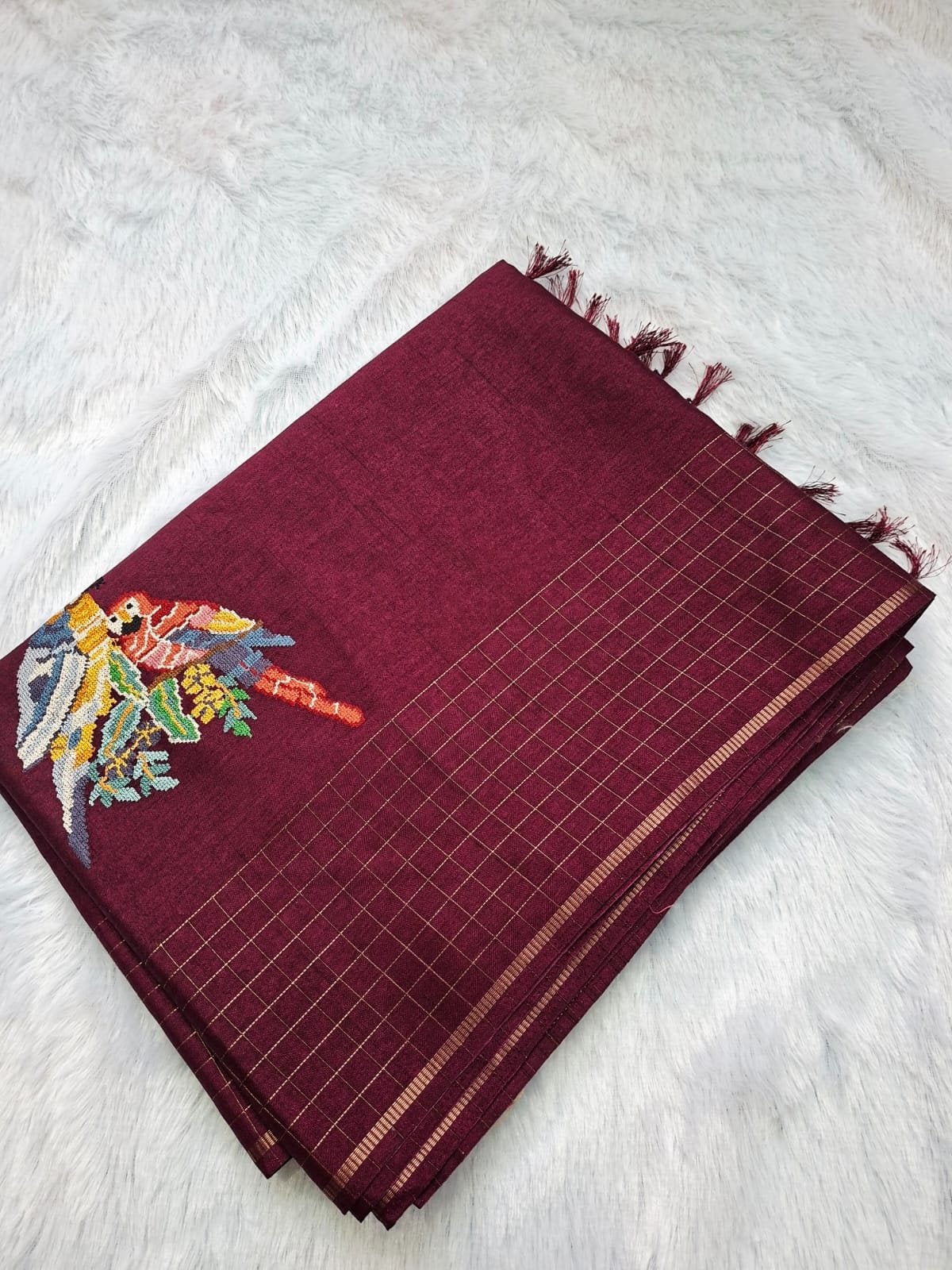 Wine viscose tussar saree with cross-stitch parrots, folded